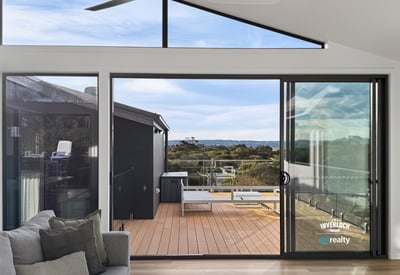 Bright and airy living space opens to a spacious deck, offering stunning views of the landscape.