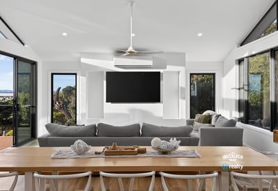 Bright, open-plan living area with panoramic views, featuring large windows and a modern, minimalist design.