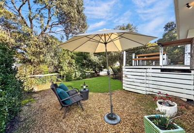 Inviting outdoor space features a shaded seating area, perfect for relaxation or entertaining amid lush greenery.