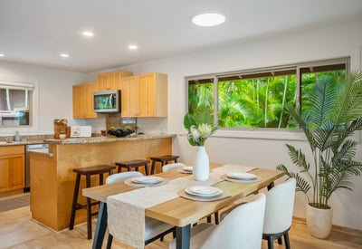 Bright, open kitchen and dining area seamlessly connect to lush outdoor views, perfect for entertaining.