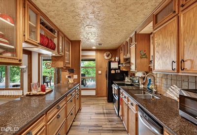 Spacious kitchen featuring ample cabinetry, granite countertops, and large windows that invite natural light.