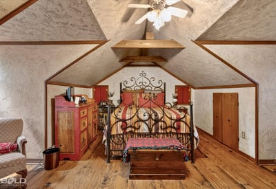 Cozy attic bedroom featuring unique architecture, rustic decor, and ample storage options for personal belongings.