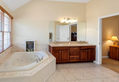 Luxurious Primary Bath with jetted tub, double vanity, and heated towel rack.