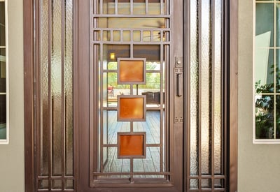 This custom iron front door makes a bold architectural statement while enhancing security and natural light, setting the tone for the craftsmanship found throughout the home.