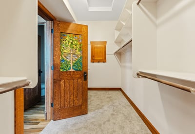 Walk-in closet offering ample shelving, hanging space, and distinctive wood detailing. Designed to combine organization, style, and character within the primary suite.