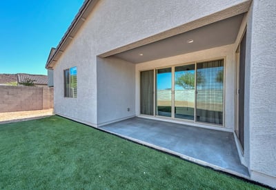 This covered patio is the perfect extension of indoor living ideal for shaded relaxation or hosting guests year-round. The smooth concrete flooring and direct access through sliding doors add comfort and convenience to this Peoria backyard retreat.