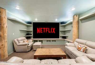 Entertainment-focused theater room with projector screen, built-in shelving, and surround-style setup for immersive movie nights.