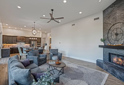 The family room connects to the kitchen with high ceilings, modern lighting, and a fireplace centerpiece for Scottsdale living.