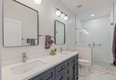 Updated hall bathroom with dual vanities, stylish lighting, and a bright, fresh design adds convenience and elegance.