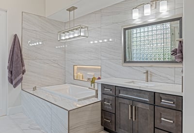 Luxurious soaking tub with marble surround, built-in bench, and dual vanities provide comfort and sophistication.