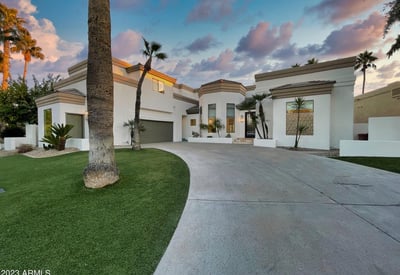 Beautiful modern architecture framed by palms and desert landscaping. The curved drive and tall windows make a bold Scottsdale impression.