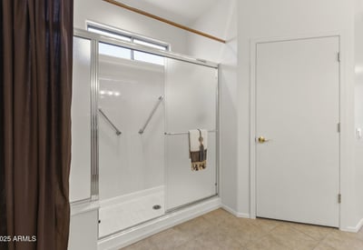 Enjoy this clean, updated bathroom featuring a large glass shower, neutral finishes, and plenty of natural light.