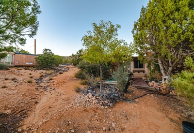 A rugged desert path winds through native plants and open terrain, demonstrating the property s generous land and serene surroundings in Hackberry.