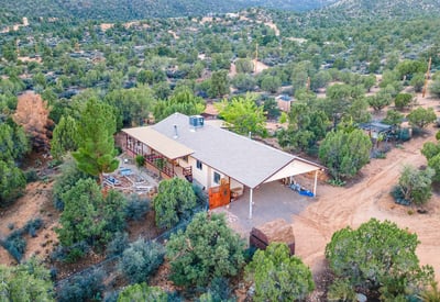 A scenic overhead view highlights the workshop structure, open land, and mountain backdrop ideal for hobbyists, equipment storage, or creative use of the acreage.