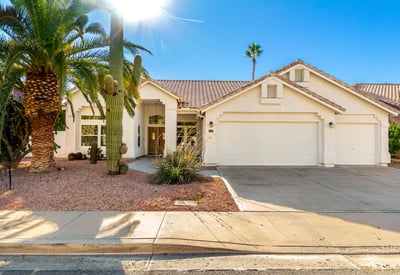 Attractive Scottsdale home exterior surrounded by mature palm trees and native desert landscaping. The well-maintained fa ade, tile roof, and inviting front walkway highlight the home's updated design and strong curb appeal.