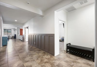 Entry corridor with a bold designer accent wall and tile flooring, creating a stylish first impression for guests.