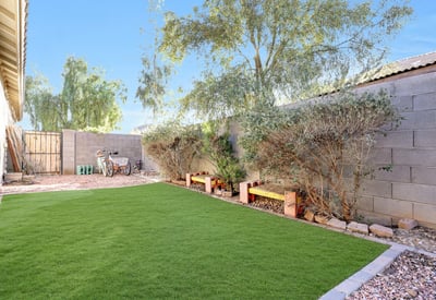 Artificial turf side yard with planter beds provides a low-maintenance, pet-friendly outdoor space designed for everyday enjoyment.