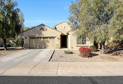 Clean front elevation with attached garage and desert landscaping, highlighting the home s single-level layout and easy-care design.