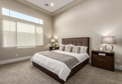 Serene primary bedroom with tall ceilings and natural light, creating a peaceful retreat within this Cave Creek residence.