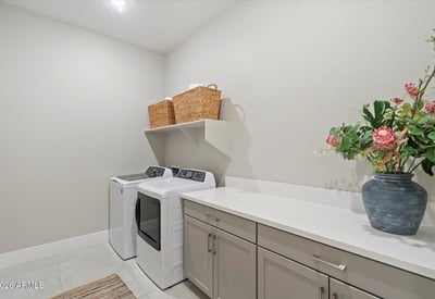 Organized laundry space with generous cabinetry and counter space, making household tasks efficient and streamlined.