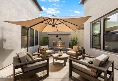 Private courtyard with gas fireplace and comfortable seating, creating a cozy outdoor living space. A signature feature of this Scottsdale luxury residence.