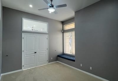 Bonus room with double doors, ceiling fan, and natural light. Ideal for a home office, media room, or guest retreat.