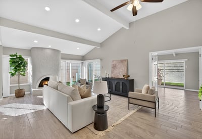 Inviting living room with vaulted ceilings, architectural fireplace, and sliding glass doors opening to private outdoor areas.