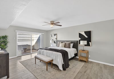 Relaxing primary suite featuring ceiling fan, soft natural light, and direct access to a private courtyard for peaceful mornings.