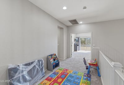 Open loft area overlooking the entryway, providing a flexible bonus space perfect for a playroom, second living room, study area, or media lounge in this Queen Creek home.