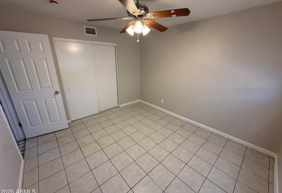 Bright bedroom with tile flooring and ceiling fan light fixture. The simple layout provides flexibility for furniture arrangement and everyday comfort.