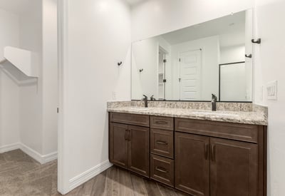 Primary bathroom with dual vanities, granite surfaces, and ample storage. A blend of style and everyday functionality.