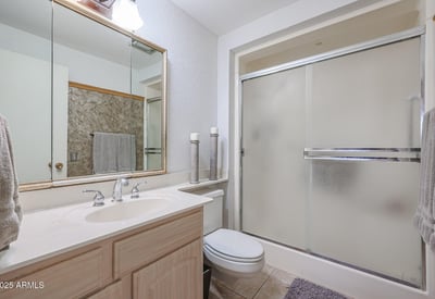 Primary bathroom with walk-in shower, large vanity, and bright lighting, designed for functionality and comfort in this Sun City property.