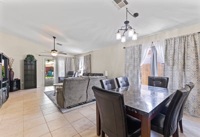 Flowing open layout connecting dining and living areas with tile flooring and natural light ideal for entertaining and daily comfort