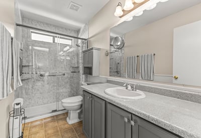 Updated bathroom featuring a walk-in shower, extended vanity, and contemporary finishes. Clean, bright, and move-in ready.