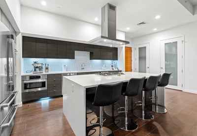 Sleek kitchen featuring a large island, stainless steel appliances, and open layout, designed for both everyday living and entertaining.