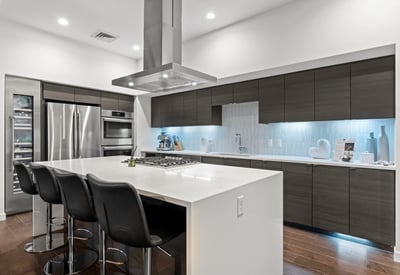 Contemporary kitchen with oversized island, built-in appliances, wine storage, and sleek cabinetry, designed for entertaining in this Phoenix residence.
