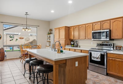 Well-designed kitchen with large island, breakfast seating, and generous cabinet storage, ideal for hosting and daily use in Phoenix.