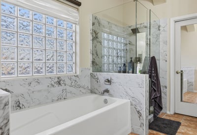 Primary bathroom with soaking tub, glass shower, and upgraded finishes, creating a relaxing and functional space in this Phoenix home.