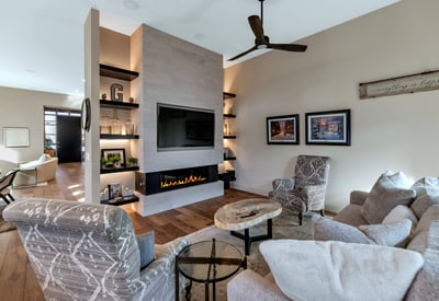 Contemporary fireplace wall with built-ins and warm finishes, adding both style and function to this Phoenix home s main living area.