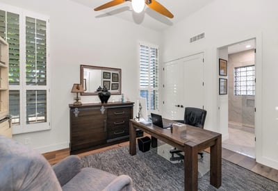 Private office with plantation shutters, natural light, and wood floors, ideal for working from home in this Phoenix property.