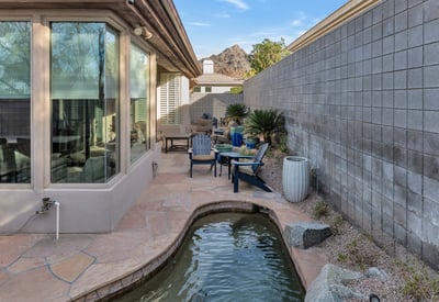 Peaceful outdoor space with a water feature, patio seating, and scenic views, offering relaxation in this Phoenix property.
