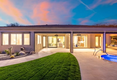 Inviting Scottsdale backyard featuring manicured grass, covered patio, and pool access, perfect for relaxing or entertaining in a private outdoor setting.