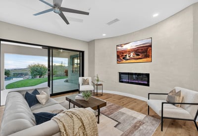 Contemporary living room with ceiling fan, neutral tones, and direct patio access, highlighting Scottsdale modern living and outdoor connection.