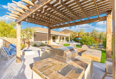 Scottsdale outdoor entertaining area with pergola, kitchen, and seating, offering a stylish and functional backyard retreat.
