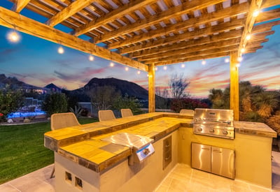 Scottsdale outdoor kitchen with built-in grill, seating area, and scenic mountain backdrop, designed for hosting gatherings.