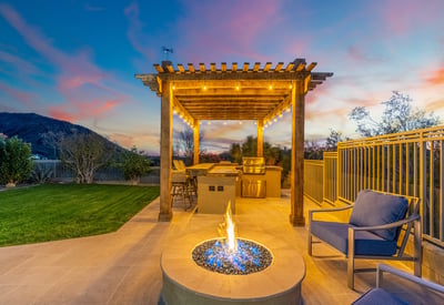 Scottsdale patio with fire pit, pergola, and outdoor kitchen area, offering a cozy and stylish entertaining space.