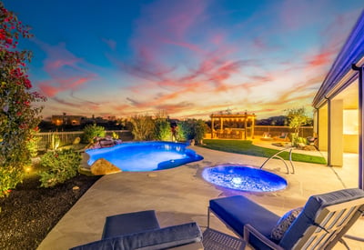 Scottsdale backyard with pool, pergola kitchen, fire pit, and sunset views, designed for upscale outdoor gatherings.