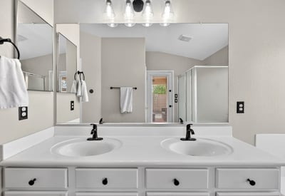 Spacious primary bathroom with dual vanities and modern fixtures. Functional layout enhances everyday convenience in Casa Grande.