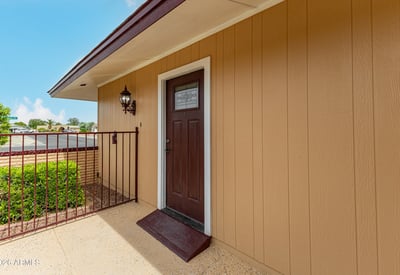 Close-up of upgraded front entry door with modern hardware. This Sun City home showcases thoughtful updates and welcoming design.