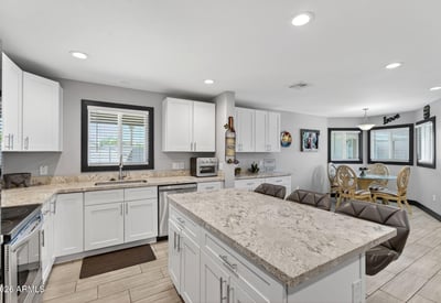 Open kitchen flowing into dining area with updated cabinetry, modern finishes, and natural light enhancing the space.